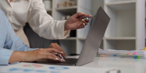 Close-up of teamwork on a laptop in an office