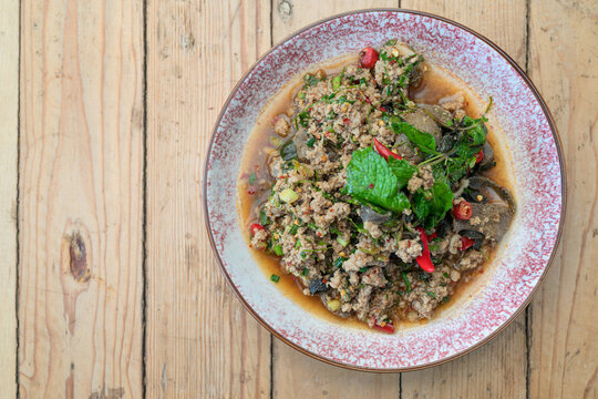 Authentic Thai Beef Larb Salad Laab Neua Spicy Ground Meat Dish on Wooden Table with Copy Space