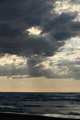 Fototapeta premium Tranquil Seascape with Sunbeams Breaking Through Clouds