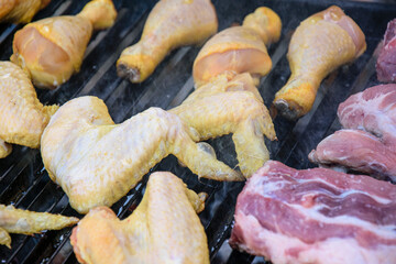 Raw chicken and pork meat on a hot barbecue grill The Concept of Outdoor Cooking