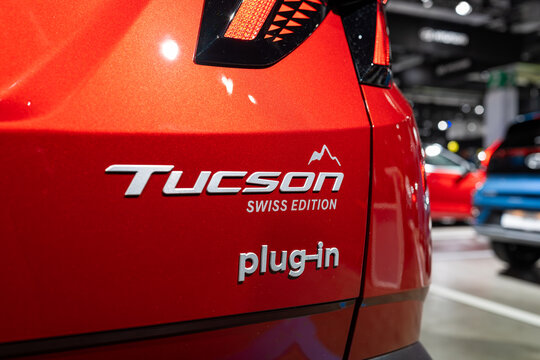 Zurich, Switzerland, October 10, 2025. Detail shot of the Tucson Swiss Edition and Plug-in hybrid badges on a red Hyundai at the Zurich Auto Show