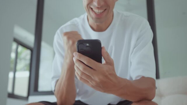 happy man checking smartphone smiling after successful online transaction or good news. happy concept showing digital lifestyle positive emotions and satisfaction with mobile banking services