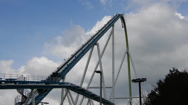 People Go up Steep Rollercoaster Ride Under Cloudy Sky