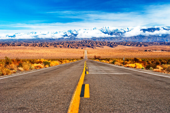 Desert Road Leading to Beautiful View of Death Valley Snow cap Mountains. Death Valley, Nevada, USA
