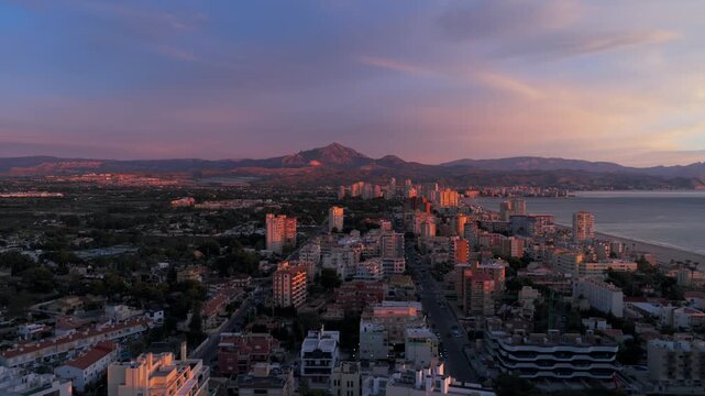 Alicante, Valencian Community, Spain - A Vibrant Cityscape With a Beautiful Coastline and Distant Mountains, All Bathed in the Soft Hues of Sunset - Orbit Drone Shot