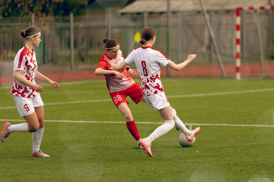 Young woman soccer players play football.