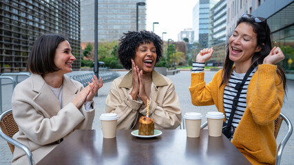Friends celebrating birthday with cake and coffee outdoors