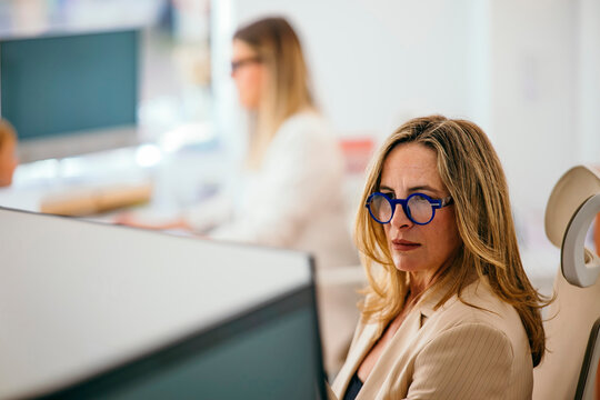 Woman working with blue glasses in open office
