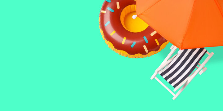 Bright donut float near a deck chair and umbrella at the beach