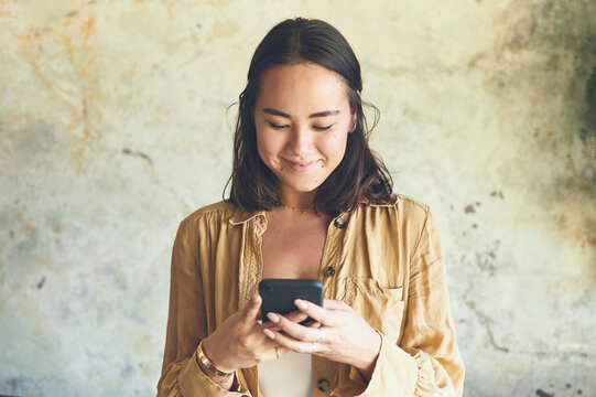 Smile, search and reading with woman and phone for streaming, ebook app and social media. Digital library, chapter release schedule and contact with person on wall background for author notes and web