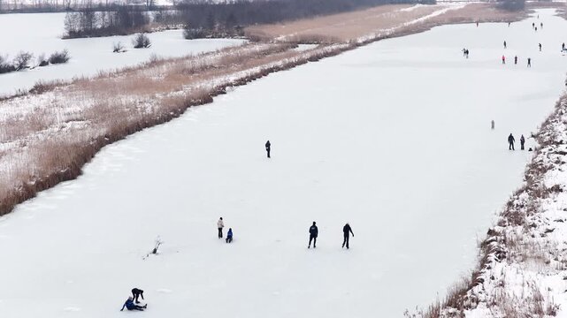 Ice skating in the Weerribben nature reserve seen from above during a cold winter day in The Netherlands.