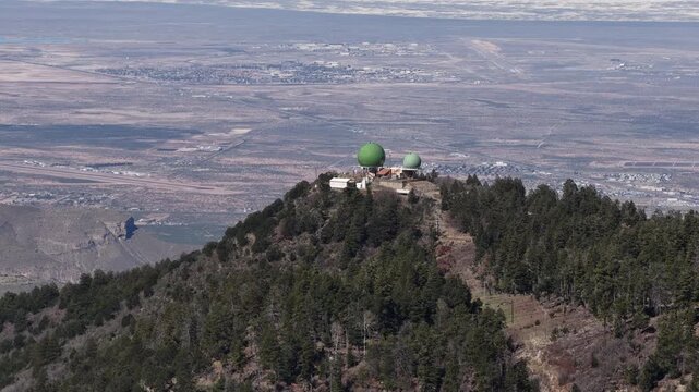 Zoom aerial of Cloudcroft New Mexico Alamo Peak Observatory in springtime with White Sands in background