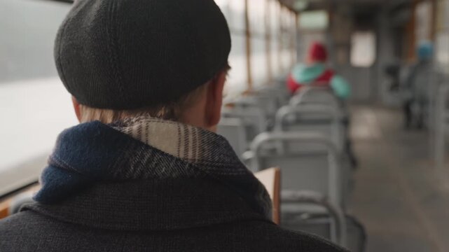 White illustrator sketching by window on ferry, back view of young white man in beret and scarf, slow travel rhythm with lake and shoreline outside, notebook pages filled with ink sketches