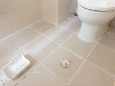 Casual view of bathroom being renovated with new grout and cleaning tools