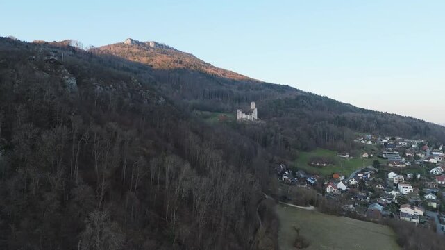Aerial view of the Neu-Bechburg Castle ruins nestled among dark trees contrasted by the town below, Oensingen, Solothurn, Switzerland.