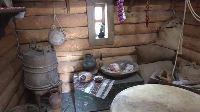 Traditional hut interior with clay pottery, food and hanging garlic and peppers