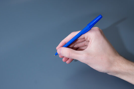 Hand Holding Blue Pen Ready to Write