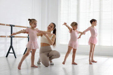 Naklejka premium Ballet teacher having class with children in dance studio