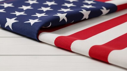 Fototapeta premium Close-up of American flag fabric with stars and stripes draped over white wooden surface for patriotic celebration or national pride events