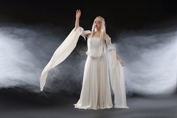 Naklejka premium Beautiful girl dressed as elf on black background with smoke