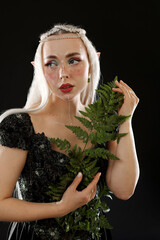 Naklejka premium Beautiful elf girl with floral decor on black background