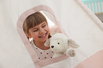 Little girl with toy sheep in wigwam at home © New Africa