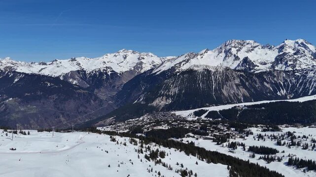 Aerial panaromic view of Courchevel 1850, ski resort 1650 and Bozel between snowy mountains.