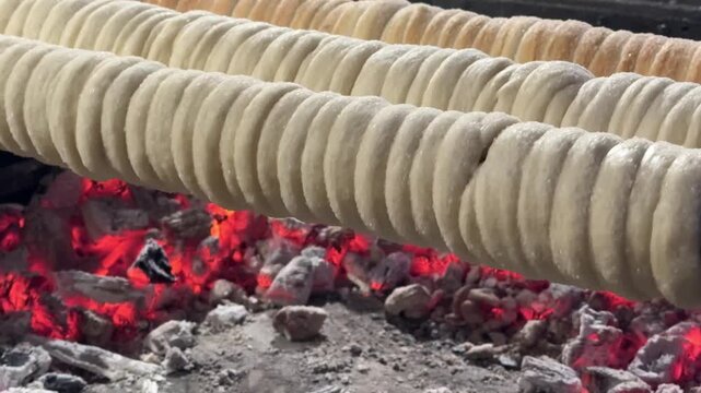 Kurtos chimney cake preparation Hungarian Czech sweet dough rolled over spit traditional baked dessert street food