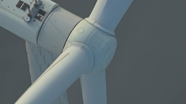 Close up of a large wind turbine rotor hub and blades turning. Renewable energy production concept at an offshore wind farm in the ijsselmeer