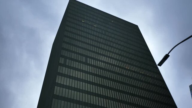 Low Angle Shot of Dark Modern Skyscraper Under Cloudy Sky