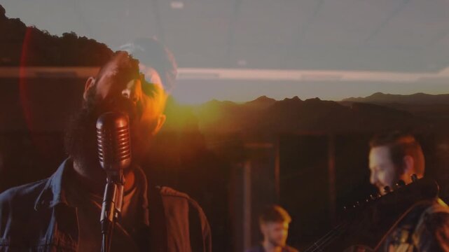 Vertical video: Singing singer in denim leaning to vintage mic in studio closeup, mountain overlay