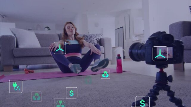 Fitness coach speaking to camera and doing seated stretches on yoga mat, talk activating help icons