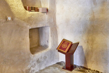 Interior of ancient Al Bidyah Mosque with holy Quran on wooden stand, Fujairah, UAE
