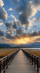 Obraz premium Wooden walkway made of bamboo is seen with people walking as the sky turns orange above the beach and ocean during sunset