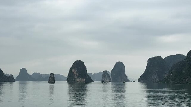 Tourist cruise boats sailing among the limestone karsts in the famous Ha Long Bay, Vietnam, tc01