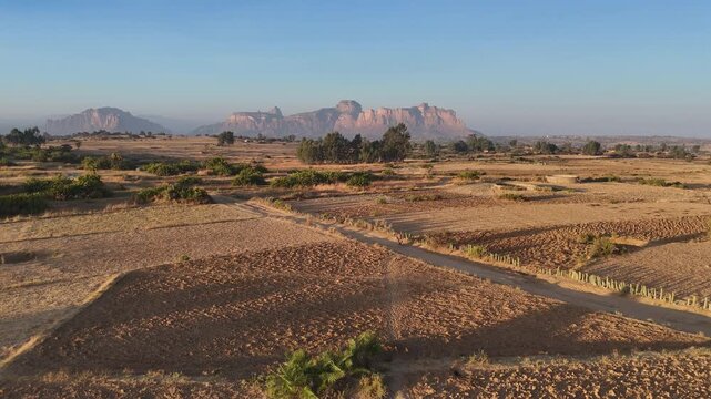 Drone view of the Gheralta range in northern Ethiopia, with cliffs and plateaus stretching across Tigray, wide aerial footage tracking a person on a bike.