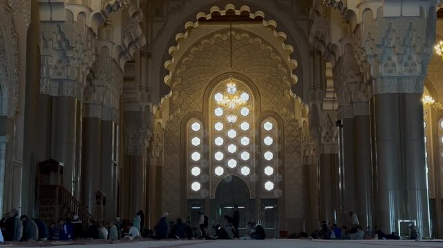 Majestic interior of Hassan II Mosque in Casablanca, Morocco. Features stunning Moorish architecture, intricate carvings, grand chandeliers, and peaceful prayer hall atmosphere. Perfect cultural asset
