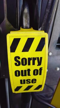 Fuel nozzle with yellow sign Sorry out of use at gas station pump close up. Fuel shortage concept reflecting global fuel crisis and rising gasoline prices with unavailable supply. Energy crisis