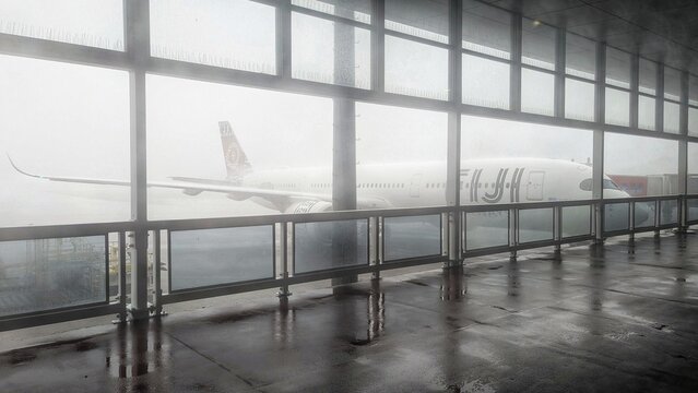 Fiji Airways airplane on runway during Cyclone Vaianu with high winds and heavy rain at Nadi International Airport, Fiji - taken on 7 April 2026