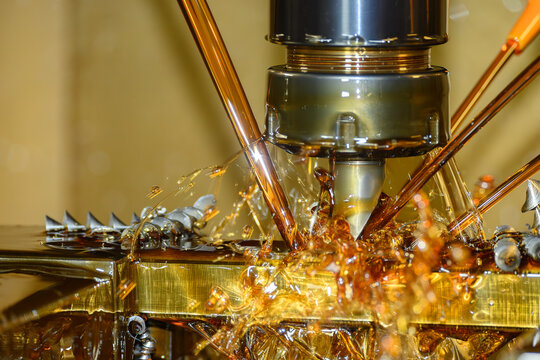 Macro shot of a high-pressure oil coolant stream during a CNC milling roughing process with indexable tooling.