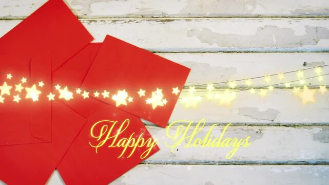 Animation of text, happy holidays, in yellow, over string lights and red envelopes on white boards