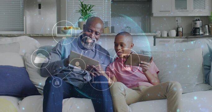 Adult tapping tablet on sofa and guiding teen boy, generating cloud icons and showing cloud network