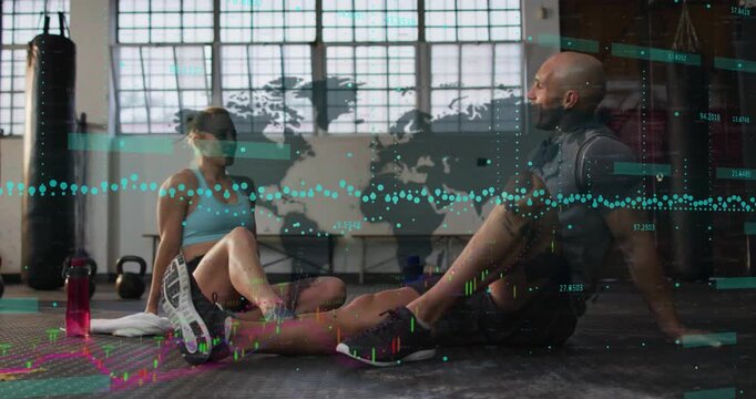 Fit pair sitting gym floor map mural, woman laughing, raising arm for high5 cheering, graphs moving
