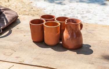 Naklejka premium Clay glasses over wooden table