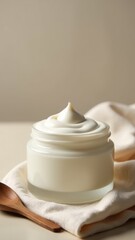 Obraz premium A jar of cream sits atop a wooden spoon, ready for use in cooking or baking