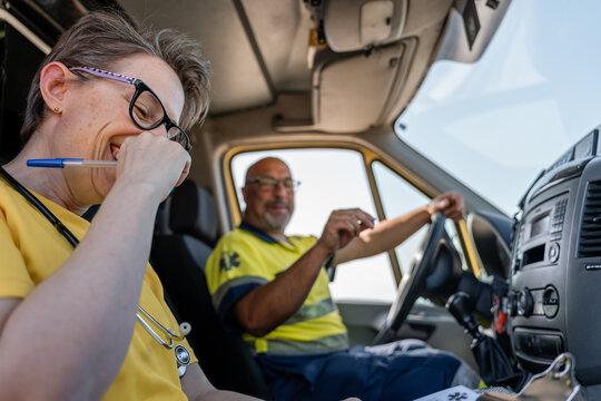Paramedics laughing and driving in ambulance during rescue mission