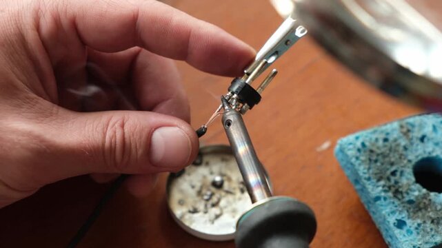 Male hands soldering wire with soldering iron