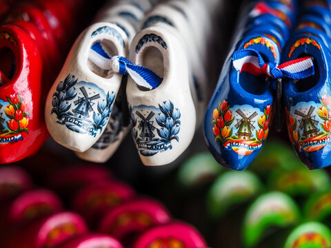 Pottery Clog shoes has red rose inside hang on black wall in Amsterdam , Netherlands , Traditional souvenir