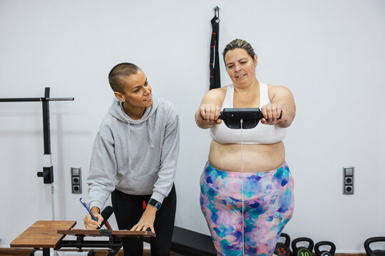Nutritionist measuring body composition of client in gym