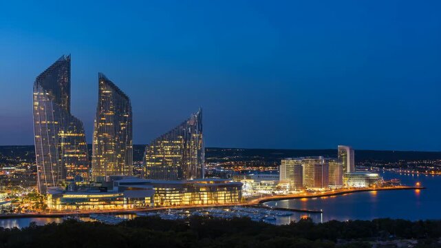 Buildings modern bayfront district with water and lights at dusk, architectural skyline. featuring cityscape, waterfront, skyscrapers with sunset and
